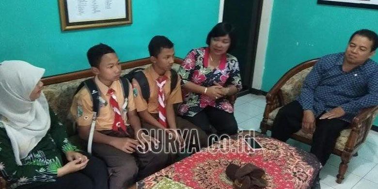 Travis dan Nur Hamid, dua dari empat siswa yang viral setelah mengembalikan dompet yang ditemukan di pinggir jalan ke pemiliknya saat dipanggil di ruang guru di SMPN 8 Kota Blitar, Jumat (9/8/2019). 



