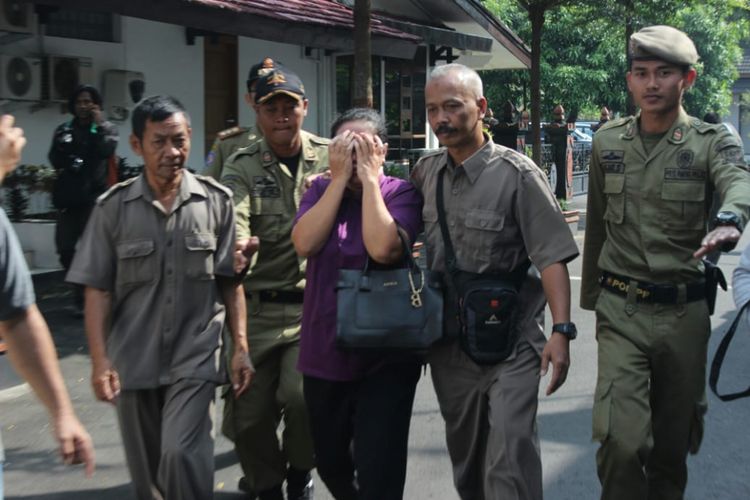 Petugas Satuan Polisi Pamong Praja (Satpol PP) mengawal seorang wanita paruh baya yang datang menggunakan mobil Toyota Velfire hitam bernomor polisi wilayah Yogyakarta masuk ke dalam rumah dinas Bupati Purbalingga, Rabu (6/6/2018)