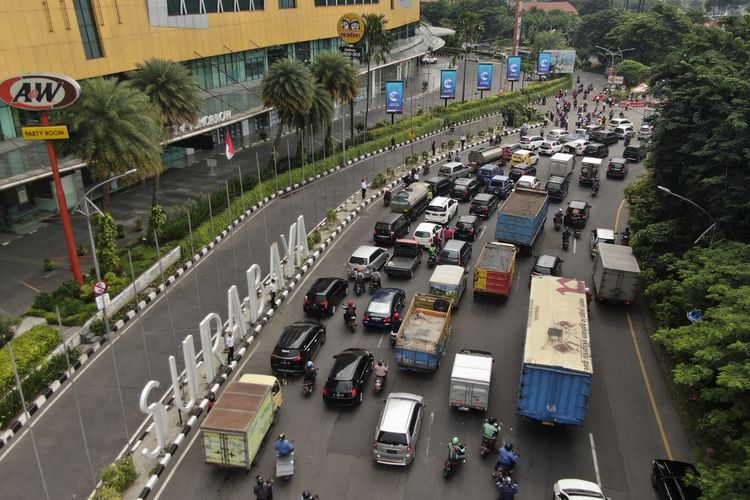 Kemacetan lalu lintas terjadi di Bundaran Waru atau tepatnya di perbatasan Surabaya dan Sidoarjo, Jawa Timur, saat hari pertama Pembatasan Sosial Berskala Besar di Kota Pahlawan, Selasa (28/4/2020).