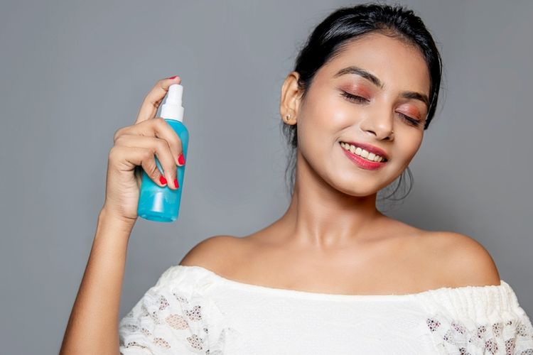 Ilustrasi seorang perempuan menggunakan setting spray. Bisakah setting spray digunakan sebelum makeup?
