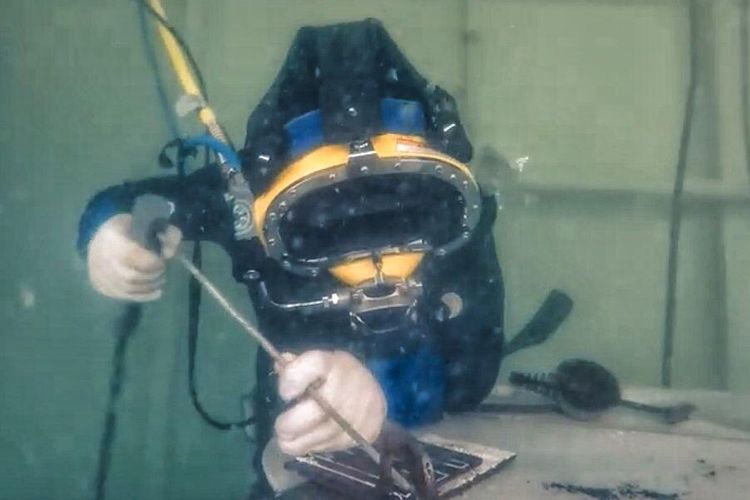 Ilustrasi pengelasan di dalam air oleh underwater welder atau ahli pengelasan.