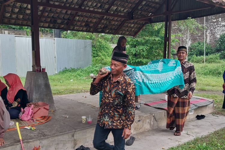 Warga memikul jodhang--peti kayu--yang ditutup kain, berisi makanan untuk tradisi Nyadran Pasar di Padukuhan Saren, Kalurahan Wedomartani, Kapanewon Ngemplak, Kabupaten Sleman, Rabu (19/2/2025).