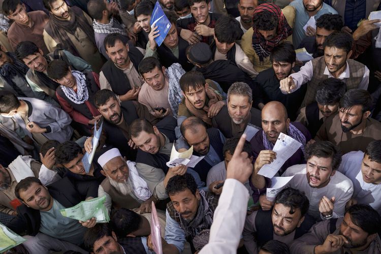 Warga Afghanistan berkumpul di luar kantor paspor pemerintah yang baru mengumumkan akan dibuka kembali setelah Taliban mengumumkan mereka akan mengeluarkan simpanan aplikasi yang disetujui oleh pemerintahan sebelumnya di Kabul, Afghanistan, Rabu, 6 Oktober 2021. 