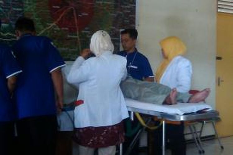 Petugas medis saat merawat salah satu warga yang pingsan