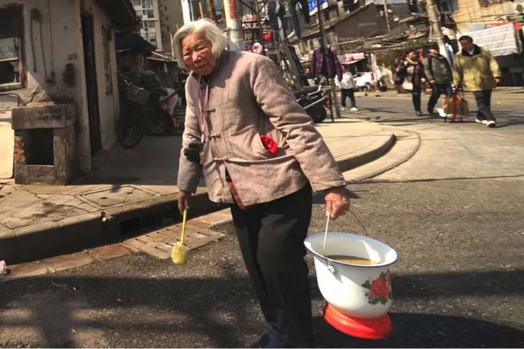 Seorang perempuan membawa pispotnya ke toilet umum di Shanghai pada Maret 2013--bulan di saat Xi Jinping terpilih menjadi presiden China.