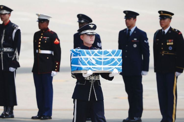 Seorang prajurit membawa sebuah peti berisi sisa jenazah tentara AS yang tewas selama Perang Korea 1950-53. Kerangka tentara AS diangkut pesawat militer dari Korea Utara dan mendarat di Pangkalan Udara Osan di Pyeongtaek, Korea Selatan,  Jumat (27/7/2018). (AFP/Kim Hong-ji)