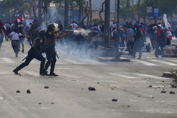 Petugas polisi menembakkan peluru gas air mata untuk membubarkan pendukung Presiden terguling Pedro Castillo di Lima, Peru, Senin, 12 Desember 2022.