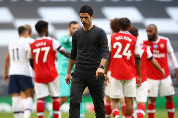 Mikel Arteta  berjalan usai kekalahan The Gunners pada laga Tottenham vs Arsenal di Tottenham Hotspur Stadium, London, Minggu (12/7/2020).