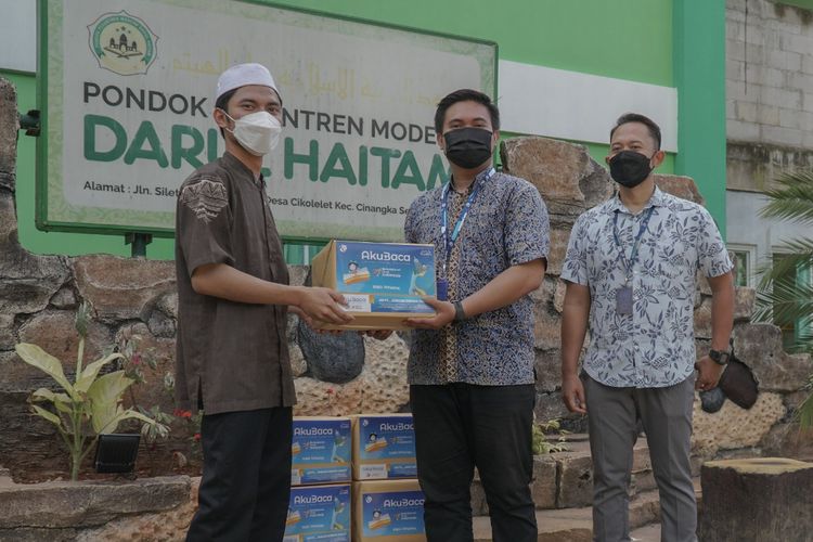 Perwakilan Pondok Pesantren Modern Darul Haitam menerima simbolis bantuan buku bacaan dari perwakilan CSR Kompas Gramedia.