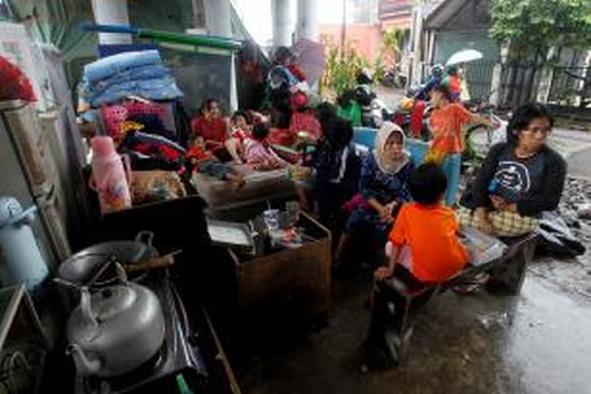 Warga Rawajati mengungsi di kolong Jembatan Kalibata, Jakarta Selatan, akibat rumah mereka yang masih terendam banjir, Selasa (21/1/2014).  KOMPAS IMAGES/KRISTIANTO PURNOMO