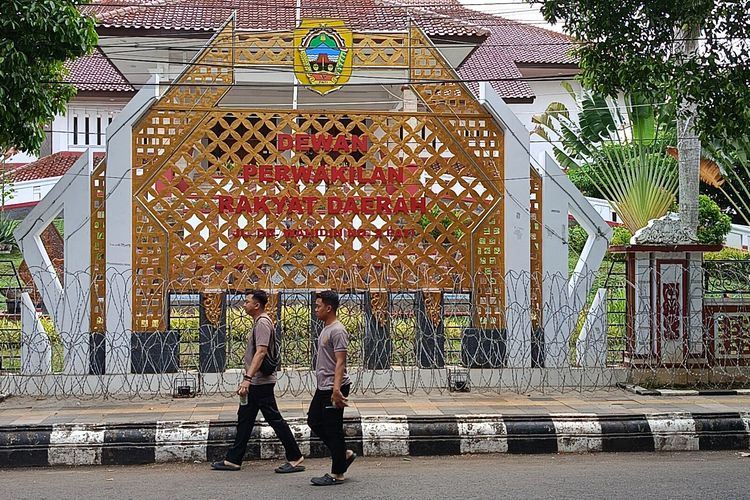 Polisi berjalan di depan kawat berduri yang dipasang di area depan gedung DPRD Pati, Jawa Tengah, Kamis (30/10/2025)