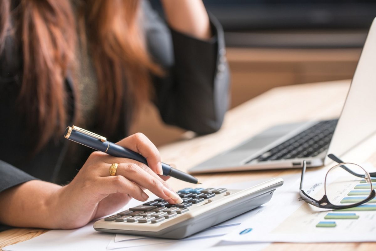 Close up of female accountant or banker making calculations. Savings, finances and economy concept