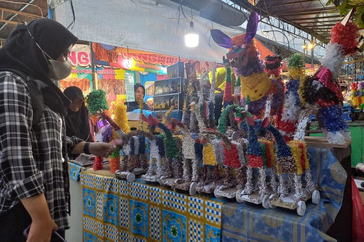 Salah satu pengunjung memilih mainan Warak Ngendog di Pasar Dugderan Semarang, Senin (4/3/2024) malam.