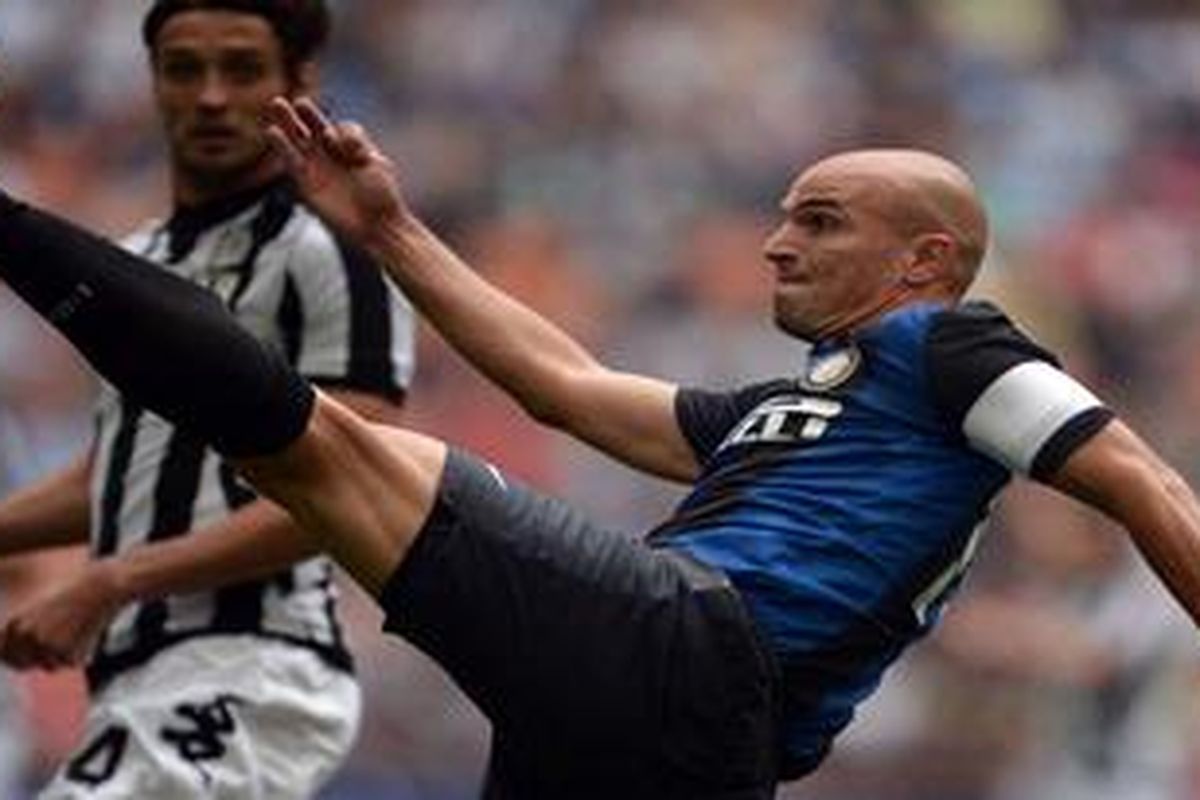 Gelandang Inter Milan, Esteban Cambiasso, berebut bola dengan pemain Siena, Massimo Paci, pada laga yang berlangsung di Stadion Giuseppe Meazza, Minggu (23/9/2012).
