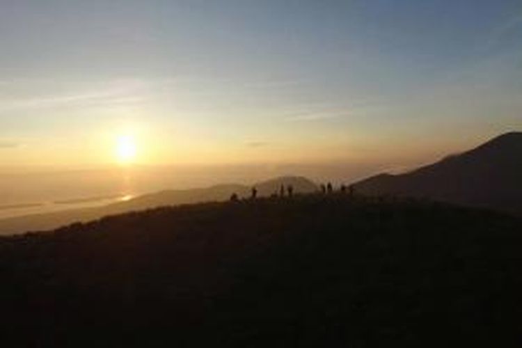 Matahari terbit di puncak Bukit Pergasingan, Lombok Timur, Nusa Tenggara Barat, Kamis (19/3/2015). Puncak Bukit Pergasingan menjadi pilihan wisata trekking di Lombok Timur untuk menyaksikan matahari terbit dan lanskap Gunung Rinjani.