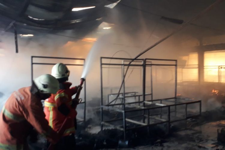 Petugas pemadam kebakaran memadamkan api di Pasar Kembang Surabaya, Minggu (22/8/2021). 