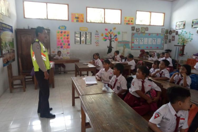 Suasana saat anggota Polres Blitar mengajar di sekolah dasar. Para polisi ini mengajar, karena kelas ditinggal gurunya untuk ikut aksi mogok massal dan demonstrasi, Rabu (26/9/2018).