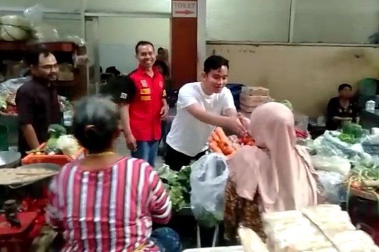 Putra sulung presiden Jokowi, Gibran Rakabuming Raka menyalami para pedagang saat blusukan ke Pasar Gading di Solo, Jawa Tengah, Selasa (10/12/2019).