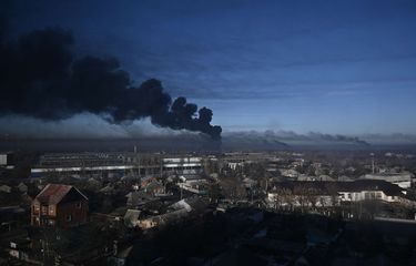 Asap hitam mengepul dari bandara militer di Chuguyev dekat Kharkiv, Ukraina, Kamis (24/2/2022). Presiden Rusia Vladimir Putin telah mengumumkan operasi militer skala penuh di Ukraina pada Kamis pagi, memberitahu pasukan Ukraina untuk meletakkan senjata mereka dan memperingatkan setiap pasukan yang mengganggu akan menghadapi konsekuensinya.