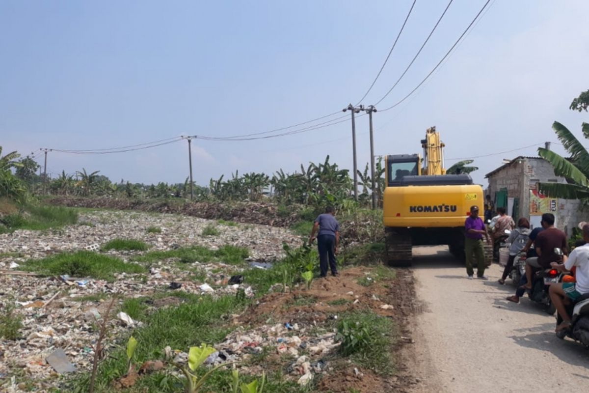 Tampak alat berat angkut lautan sampah di Kali Pisang Batu, Desa Pahlawan Setia, Tarumajaya, Kabupaten Bekasi, Minggu (6/1/2019).