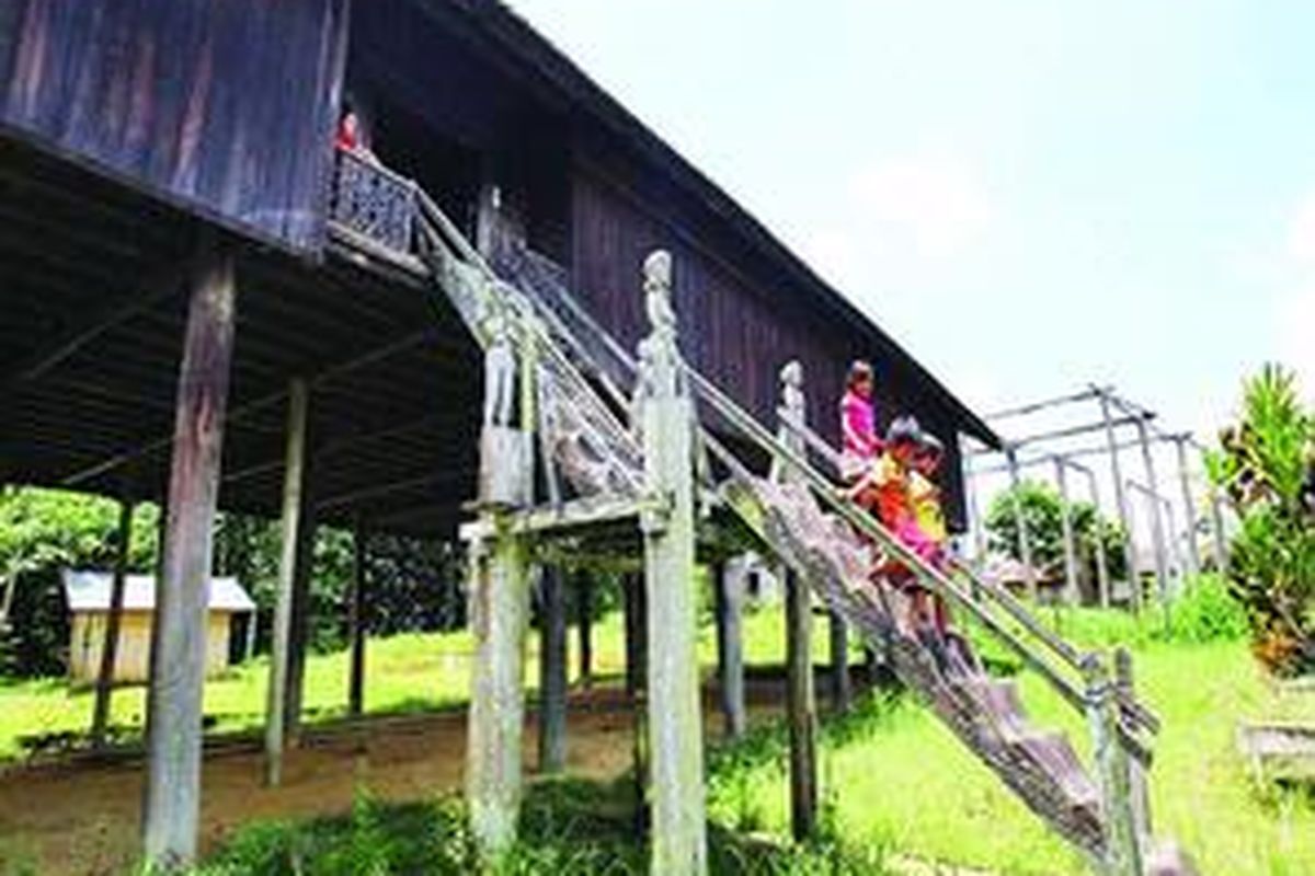 Anak-anak bermain di depan rumah betang Damang Batu, Kabupaten Gunung Mas, Kamis (10/3). Pada tahun 1894, Tumbang Anoi menjadi tempat pertemuan para pemimpin suku Dayak.