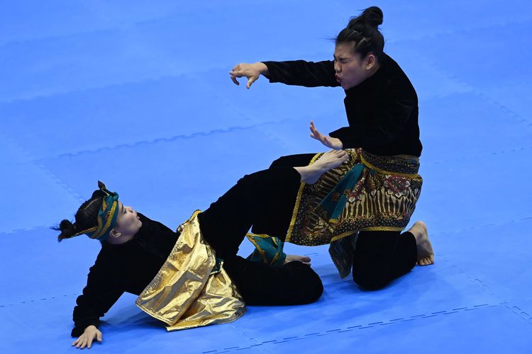 Pesilat Indonesia Riska Hermawan (kanan) dan Ririn Rinasih (kiri) berlaga dalam pertandingan babak perempat final Nomor Seni Ganda Putri Pencak Silat SEA Games 2021 Vietnam di Bac Tu Liem Sport Center, Hanoi, Selasa (10/5/2022). Riska dan Ririn menang dari pesilat Filipina Jeremae Beato dan Mitz Jude dengan skor akhir 9.930-9.900.