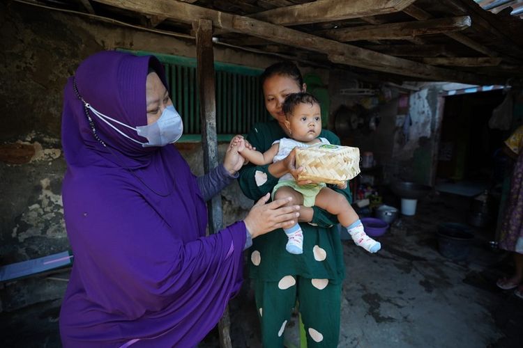 Petugas menyerahkan paket daging kurban kepada orang tua yang memiliki anak stunting di Kota Madiun. Bantuan itu diharapkan dapat menambah asupan gizi bagianak-anak di Kota Madiun, Jawa Timur yang masih berstatus stunting.