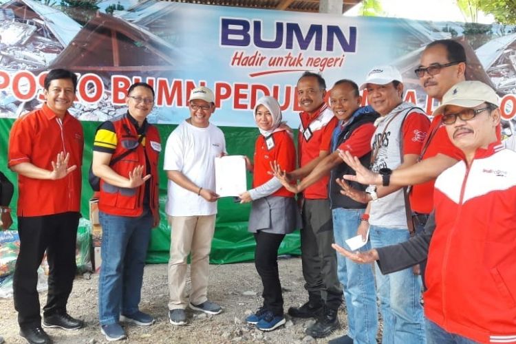 Direktur Consumer Service Telkom Siti Choiriana (kelima dari kiri) menyerahkan simbolis bantuan TelkomGroup kepada perwakilan penerima bantuan di Posko BUMN Peduli, Lombok NTB (8/8).