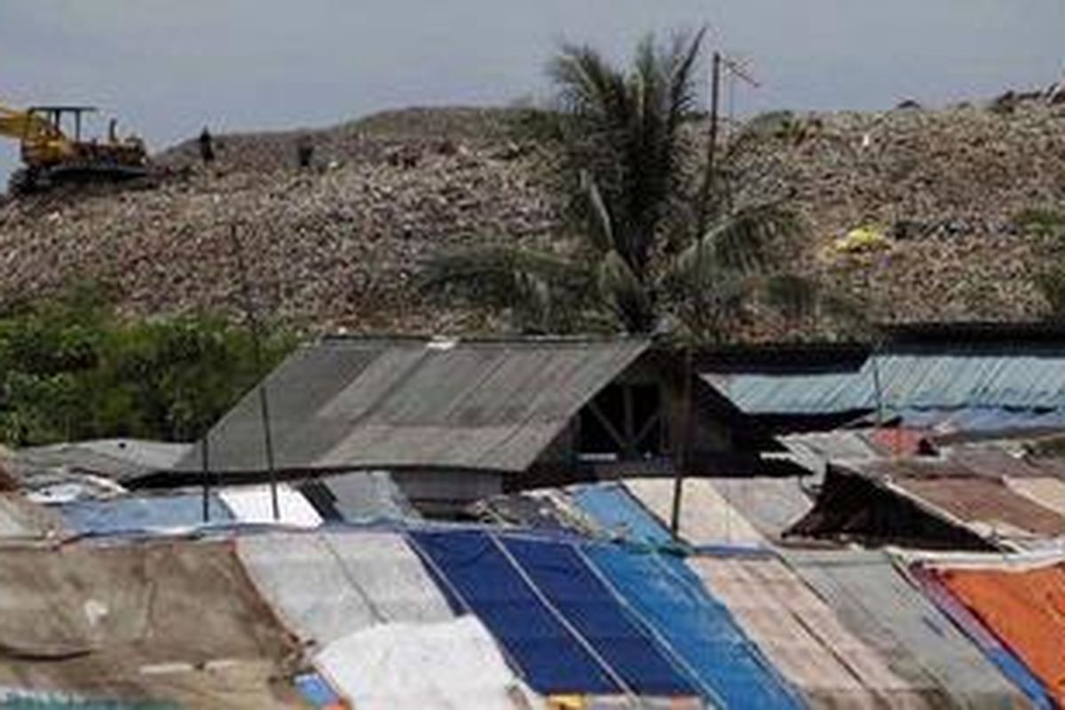 Alat berat meratakan gunungan sampah di atas perkampungan pemulung Sumurbatu, Kecamatan Bantargebang, Bekasi, Jawa Barat, Senin (23/3/2010). Ratusan pemulung hidup berbaur dengan sampah yang tiap hari terkumpul di Tempat Pembuangan Akhir Bantargebang.