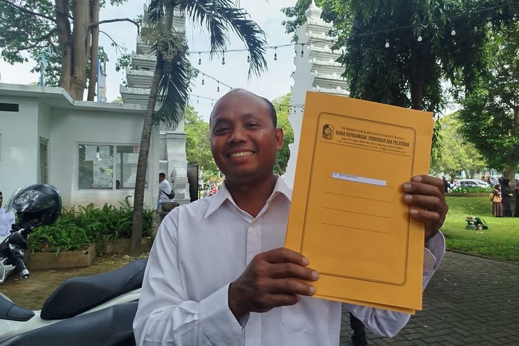 Budi Indiyanto menunjukkan SK pengangkatan PPPK di Pendopo Sabha Swagata Blambangan, Jumat (23/5/2025).