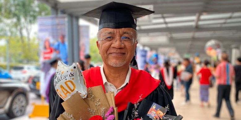 Abah Aiman berpose mengenakan pakaian wisuda beserta pernak-pernik lainnya di hari kelulusan sang putra dari perguruan tinggi.