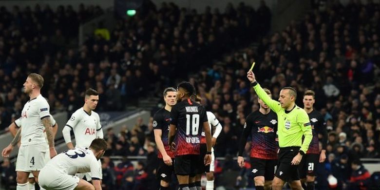 Wasit Cuneyt Cakir memberikan kartu kuning untuk Ben Davies pada laga leg pertama babak 16 besar Liga Champions Tottenham vs Leipzig di Stadion Tottenham, Rabu (19/2/2020) atau Kamis dini hari WIB. 