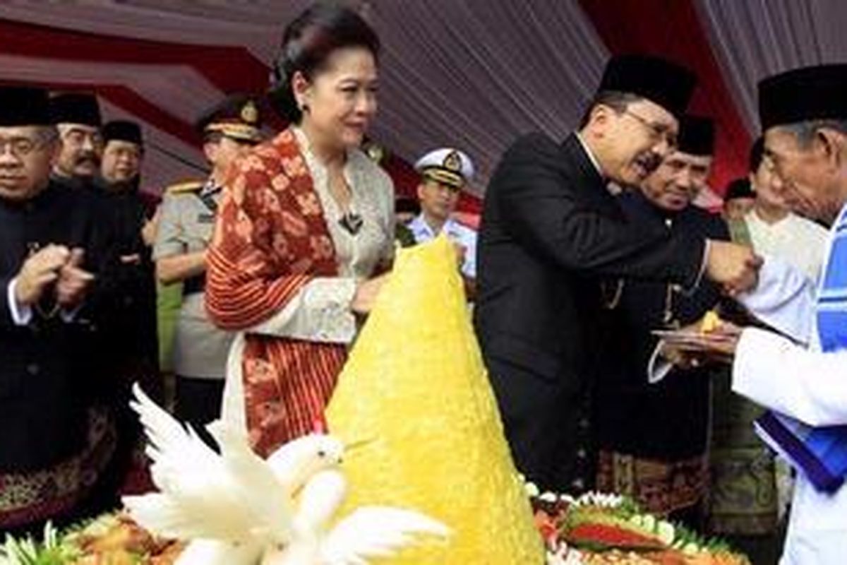 Gubernur DKI Jakarta, Fauzi Bowo memberikan potongan nasi tumpeng kepada Ridwansyah (54) saat Apel Peringatan HUT ke-483 kota Jakarta di Halaman Monumen Nasinal (Monas), Jakarta, Selasa (22/6/2010). Ridwansyah adalah pegawai Dinas Pekerjaan Umum (DKP) Jakarta Pusat. Hari kelahirannya tepat bersamaan dengan HUT kota Jakarta ke-483