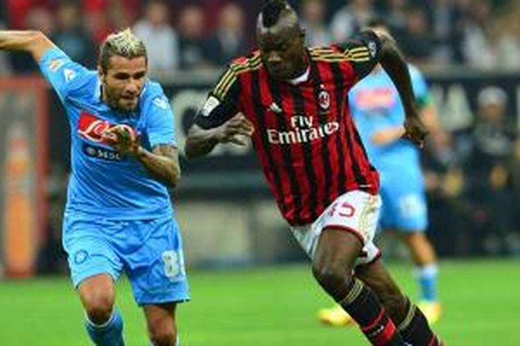 Gelandang Napoli asal Swiss Valon Behrami (kiri) berebut bola dengan striker AC Milan Mario Balotelli dalam pertandingan Serie-A di San Siro, Minggu (22/9/2013).