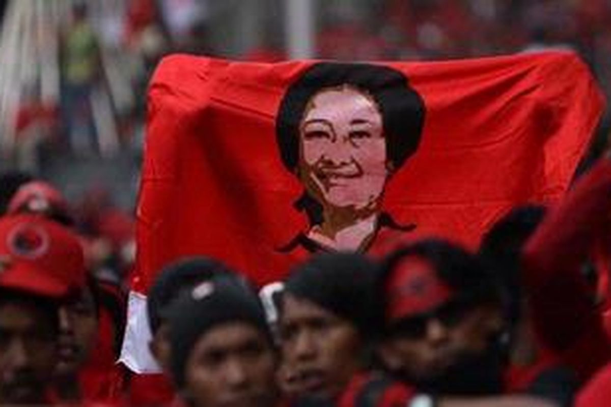 Simpatisan Partai Demokrasi Indonesia Perjuangan (PDI-P) membawa poster bergambar Ketua Umum PDI-P Megawati Soekarnoputri.