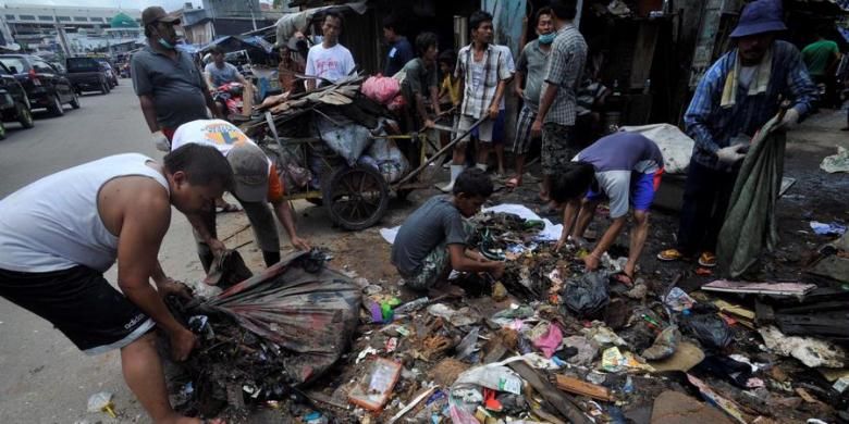 Warga kampung Muara Baru di RW 17 Kelurahan Penjaringan, Jakarta Utara, bergotong royong membersihkan sampah bekas banjir yang mengotori permukiman mereka, Minggu (27/1/2013). Warga berharap sampah-sampah bekas banjir dapat segera diangkut supaya tidak mencemari dan membuat bau di lingkungan mereka.

