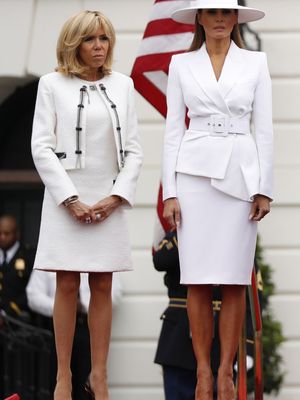 Melania Trump berdiri di samping Brigitte Macron.