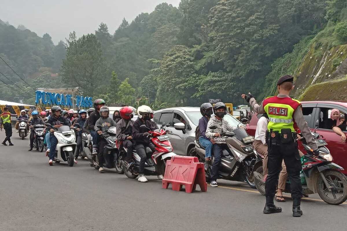 Kepadatan kendaraan di kawasan Puncak Pass Cianjur, Jawa Barat, Minggu (30/4/2023) siang. Petugas tengah memberlakukan one way dari arah Bogor menuju Puncak