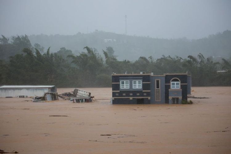 Sebuah rumah terendam banjir akibat Badai Fiona di Cayey, Puerto Rico, Minggu, 18 September 2022. Menurut pihak berwenang, tiga orang berada di dalam rumah dan dilaporkan telah diselamatkan. 