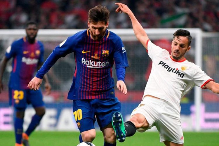 Barcelona Lionel Messi (kiri) bersaing dengan gelandang Sevilla, Pablo Sarabia, pada final Copa del Rey di stadion Wanda Metropolitano, Madrid, Minggu (22/4/2018)
