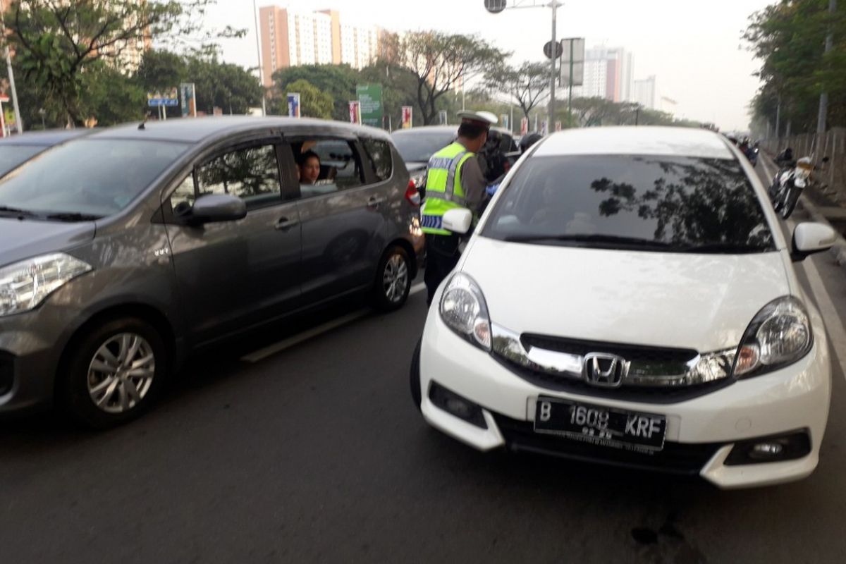 Polisi menghentikan mobil yang melanggar aturan ganjil-genap di Jalan Benyamin Sueb, Jakarta Utara, Rabu (1/8/2018).