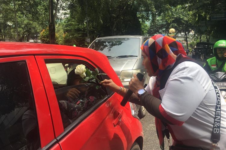 Seorang anggota massa aksi membagikan mawar putih kepada pengendara mobil yang melintas di depan gedung DPRD Sumut, Kamis (3/9/2019). Aksi damai ini sebagai bentuk protes aksi unjuk rasa yang akhir-akhir ini berujung ricuh.