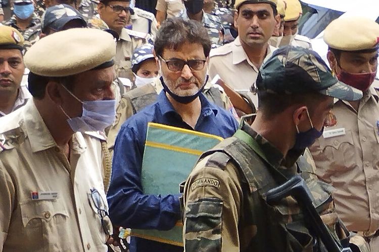 Pemimpin separatis Kashmir Yasin Malik dikawal oleh petugas polisi ke pengadilan di New Delhi, India, Rabu, 25 Mei 2022. 