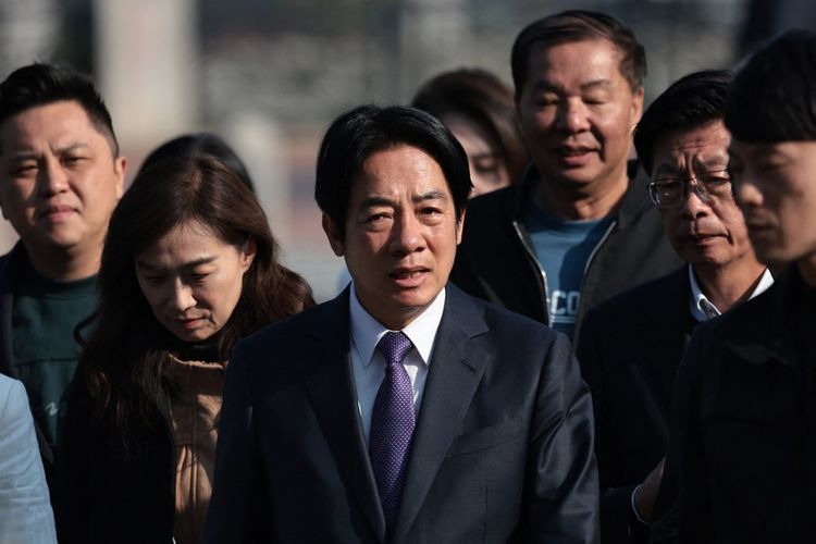 Wakil Presiden Taiwan dan calon presiden dari Partai Progresif Demokratik (DPP) yang berkuasa, Lai Ching-te (tengah) tiba untuk memberikan suara dalam PilpresTaiwan di tempat pemungutan suara di sebuah sekolah menengah di Tainan pada 13 Januari 2024.