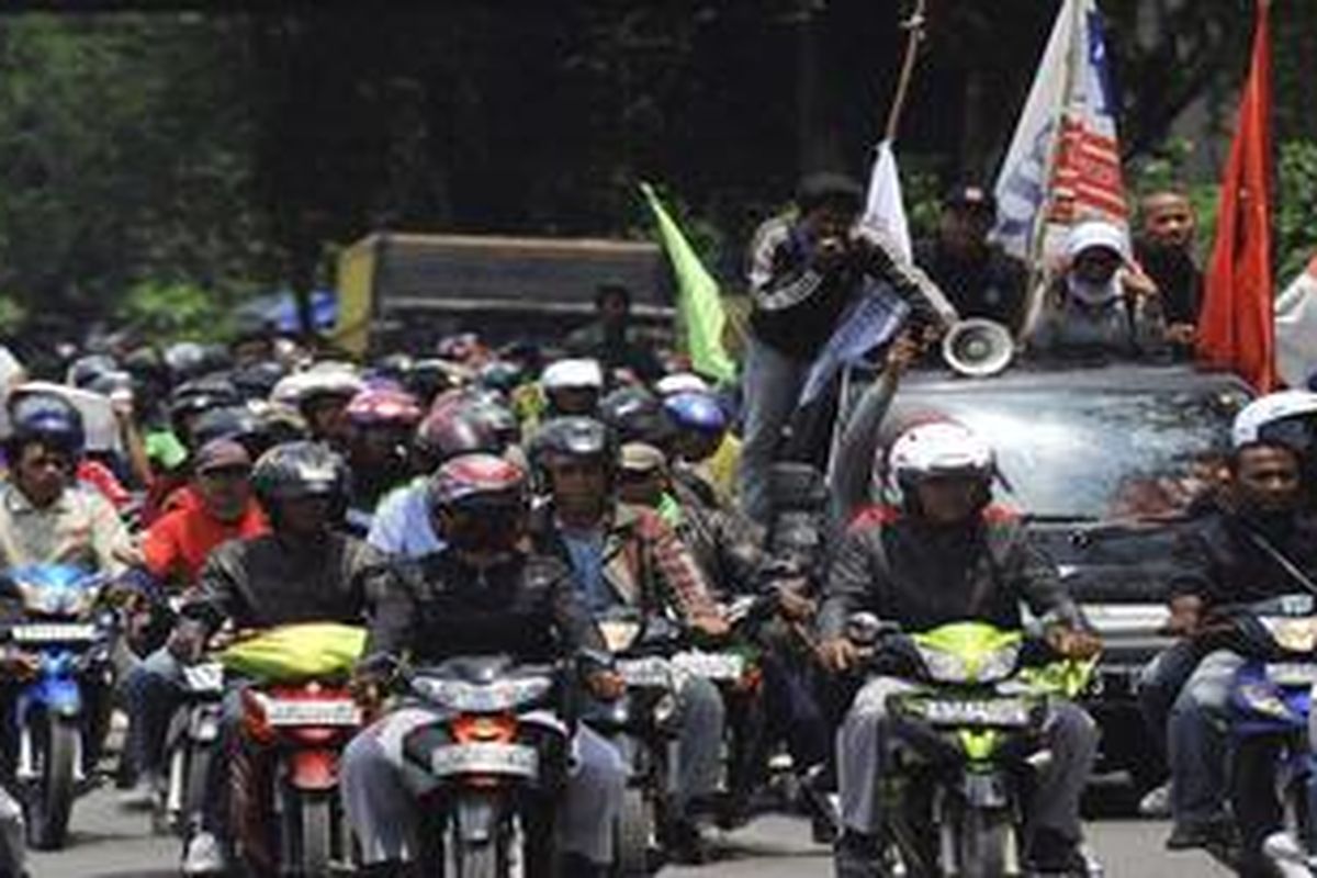 Buruh pabrik yang ada di Tangerang, Banten konvoi dengan kendaraan melewati sekitar pintu keluar dan masuk tol Bitung saat unjuk rasa, Kamis (26/1/2012). Unjuk rasa tersebut untuk mendesak Asosiasi Pengusaha Indonesia mencabut gugatannya ke PTUN atas SK Gubernur Banten yang merevisi Upah Minimum Kabupaten dan Upah Minimum Sektoral.