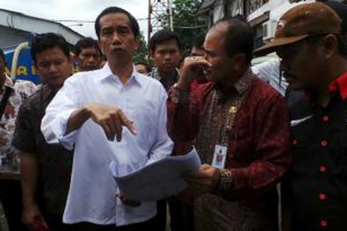 Gubernur DKI Jakarta Joko Widodo mengunjungi korban banjir di Rawa Buaya, Cengkareng, Jakarta Barat, Kamis (16/1/2014). Di sana ia menyerahkan bantuan berupa beras dan alat-alat tulis.