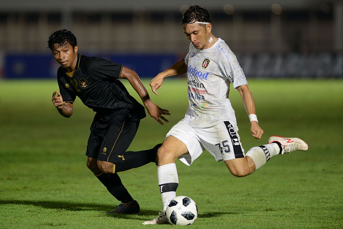 Pesepak bola Bali United Michael Orah (kanan) menembakkan bola dengan dibayang-bayangi pesepak bola Tim Nasional (Timnas) U-23 Muhammad Rifad dalam pertandingan uji coba di Stadion Madya, Gelora Bung Karno (GBK), Jakarta, Minggu (7/3/2021). Pertandingan dimenangkan Timnas U-23 dengan skor 3-1.