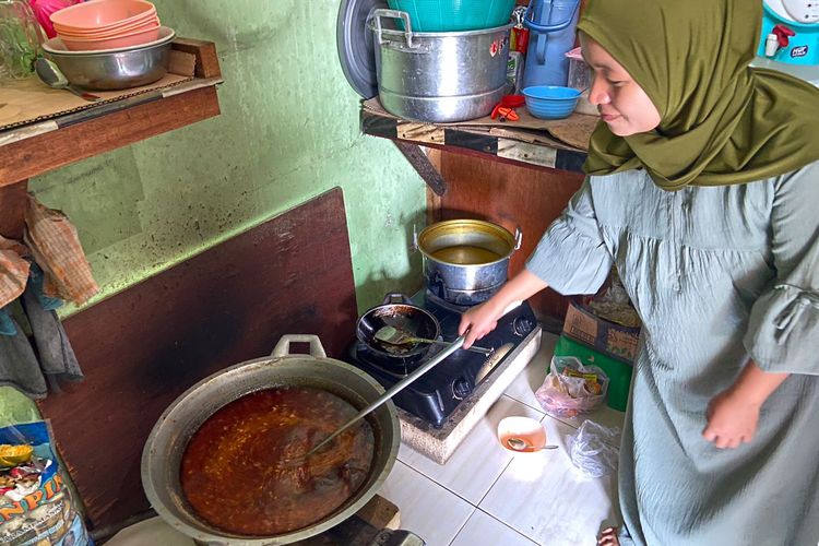 Rofiah (27) saat memasak bumbu hitam untuk bikin bebek goreng khas Madura