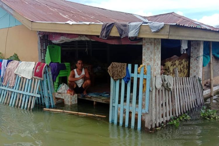 Seorang warga Desa Hutadaa bertahan di dalam rumah dengan membangun panggung papan di dalam rumah untuk bertahan hidup di atas luapan air Danau Limboto, Rabu (19/4/2023). Sebagian warga lainnya memilih meninggalkan rumah untuk mengungsi ke tempat yang aman.