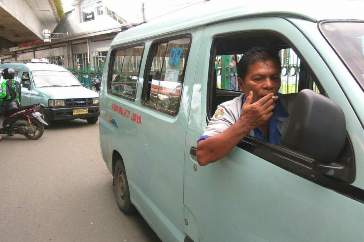 Panjaitan seorang sopir angkot 08 rute Tanah Abang-Kota yang sedang menunggu penumpang di bawah flyover Stasiun Tanah Abang.